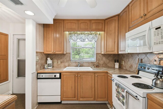 kitchen with white appliances, a sink, tile counters, decorative backsplash, and ceiling fan