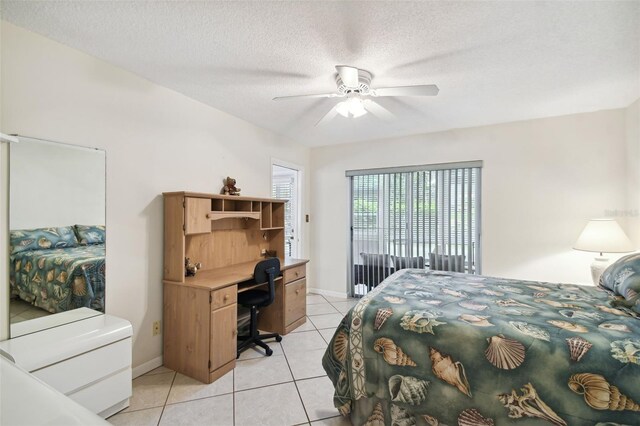 bedroom with light tile patterned floors, a desk, a textured ceiling, a ceiling fan, and baseboards