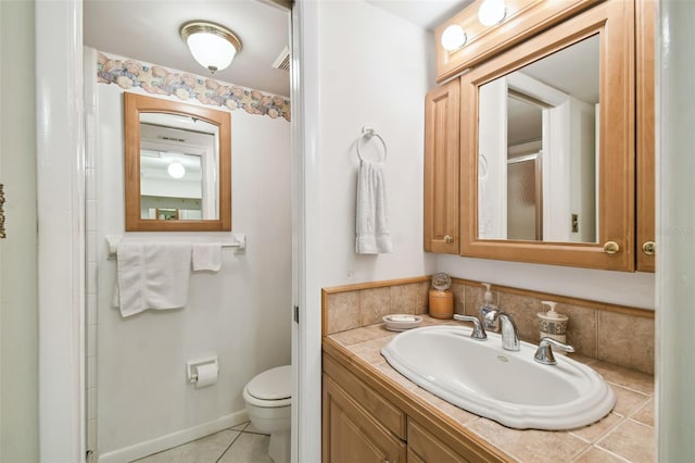 bathroom with vanity, toilet, and tile patterned floors