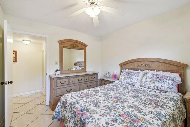bedroom with light tile patterned floors, ceiling fan, and baseboards