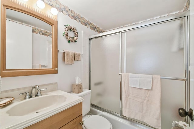 full bathroom with enclosed tub / shower combo, toilet, and vanity