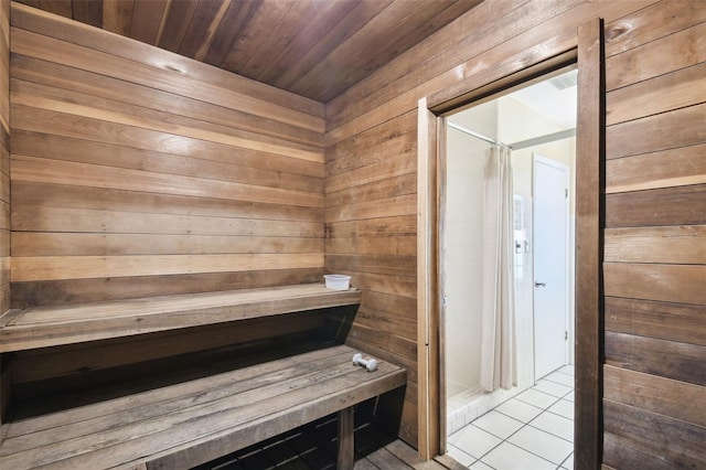 view of sauna / steam room featuring tile patterned flooring and wood walls