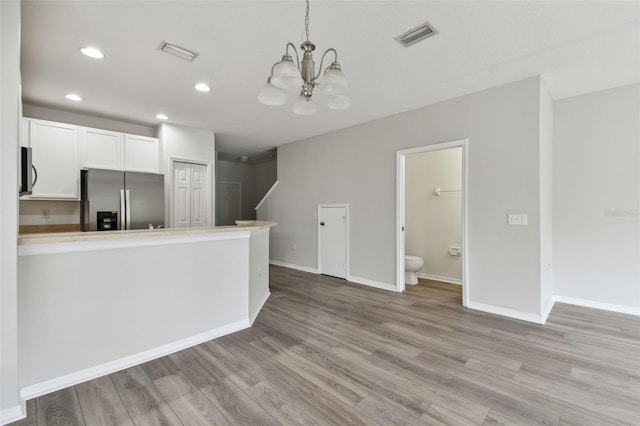 20461 Berrywood Ln, Tampa, FL 33647 - kitchen with visible vents, appliances with stainless steel finishes, a chandelier, and light wood-type flooring