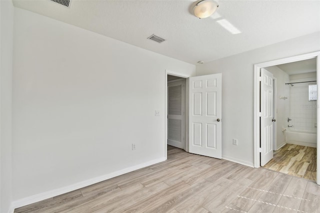 20461 Berrywood Ln, Tampa, FL 33647 - unfurnished bedroom featuring visible vents, connected bathroom, baseboards, and light wood-type flooring