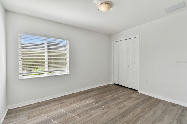20461 Berrywood Ln, Tampa, FL 33647 - unfurnished bedroom featuring baseboards, visible vents, wood finished floors, and a closet