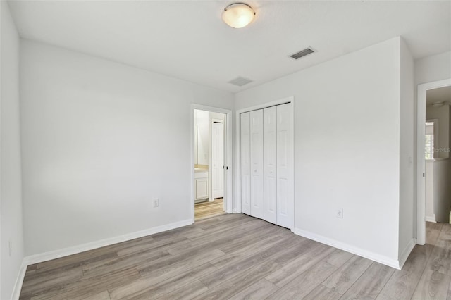 unfurnished bedroom featuring a closet and light wood-type flooring