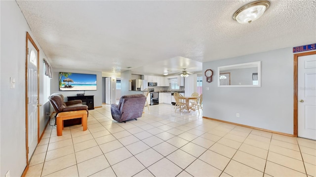 tiled living room featuring ceiling fan and a textured ceiling