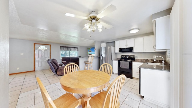 tiled dining room with a textured ceiling, ceiling fan, and sink