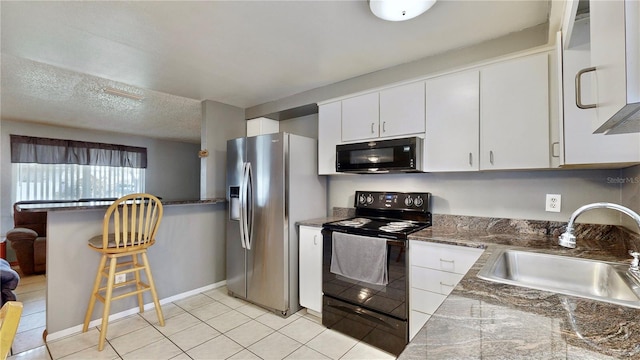 kitchen featuring white cabinetry, sink, a textured ceiling, light tile patterned floors, and black appliances