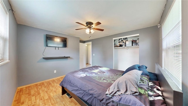 bedroom with a closet, hardwood / wood-style flooring, and ceiling fan