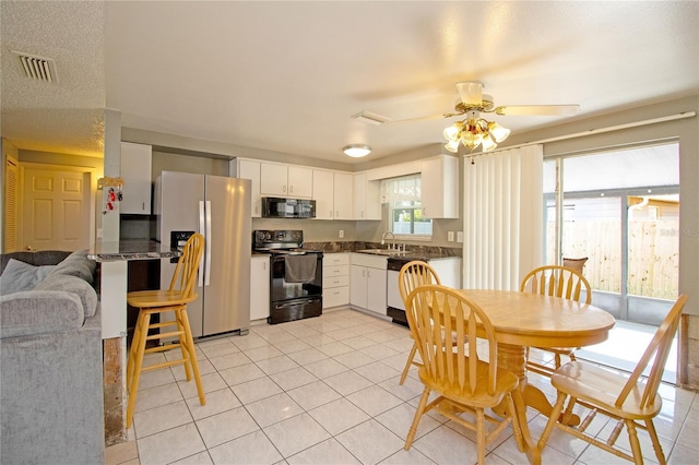 kitchen with ceiling fan, sink, dark stone countertops, white cabinets, and black appliances