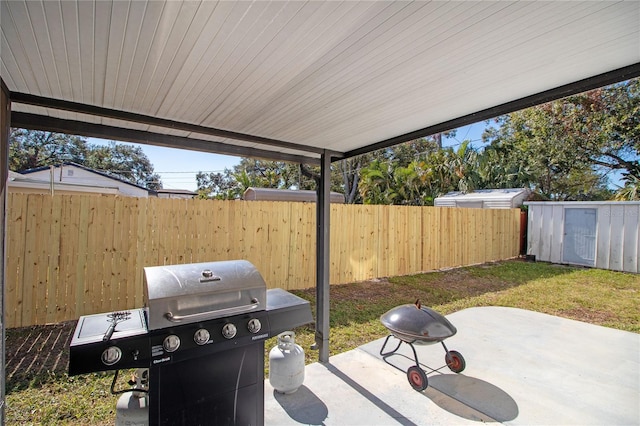 view of patio / terrace with a storage shed and a grill