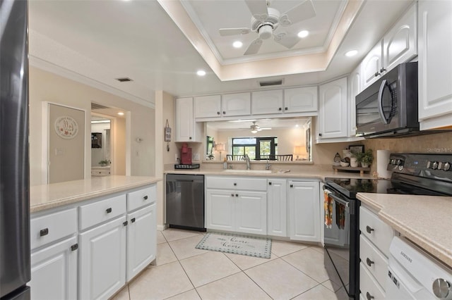 kitchen with white cabinets, appliances with stainless steel finishes, sink, a tray ceiling, and ceiling fan