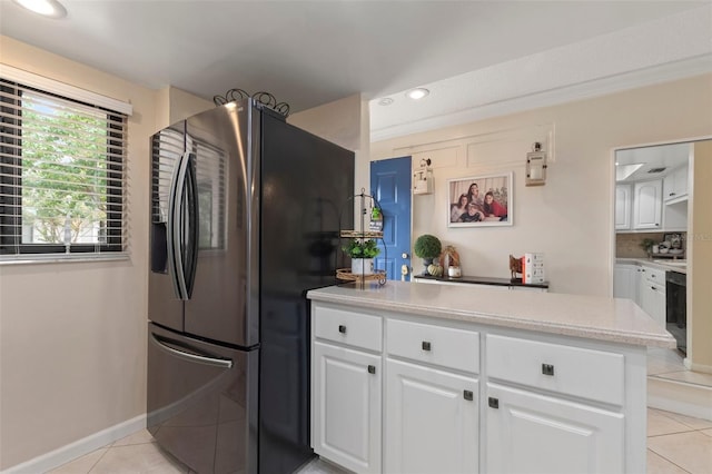 kitchen featuring stainless steel fridge, white cabinetry, backsplash, and light tile patterned floors