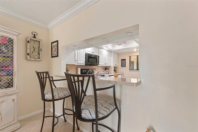 kitchen with crown molding, white cabinetry, a textured ceiling, backsplash, and light tile patterned floors