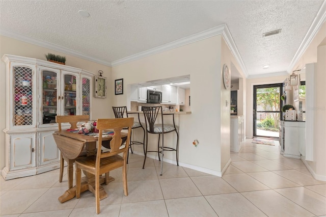 tiled dining area with ornamental molding and a textured ceiling