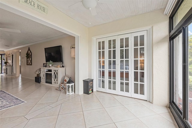 unfurnished sunroom featuring ceiling fan