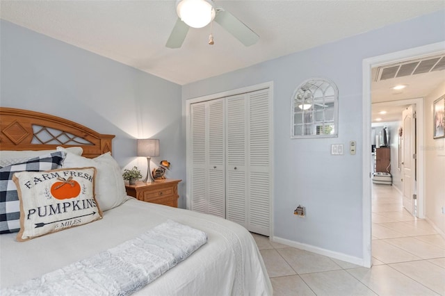 tiled bedroom featuring ceiling fan and a closet