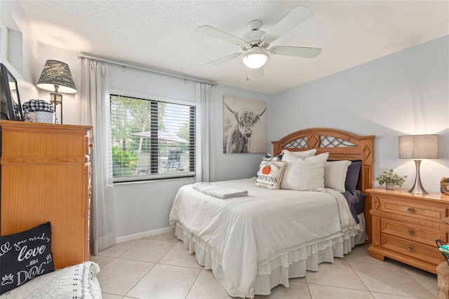 bedroom featuring a textured ceiling, light tile patterned flooring, and ceiling fan