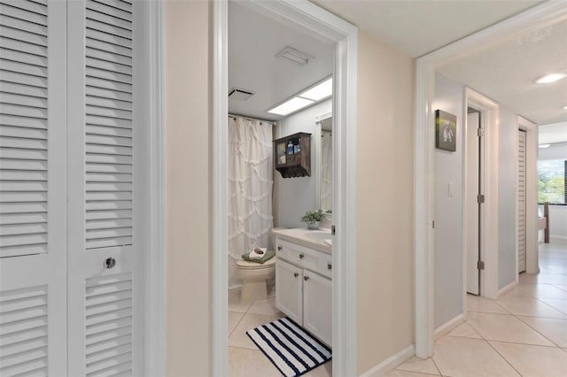 corridor featuring sink and light tile patterned floors