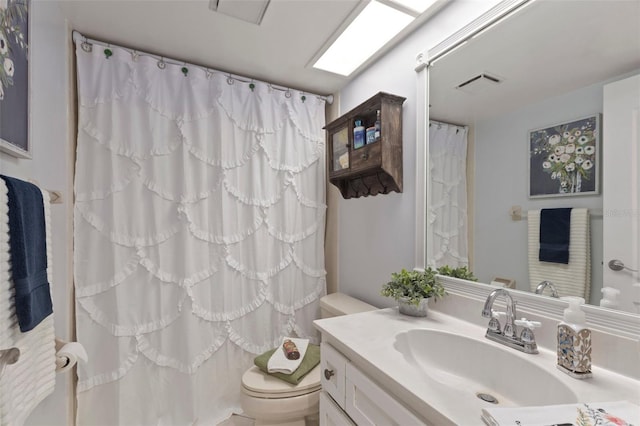 bathroom featuring vanity, toilet, and curtained shower