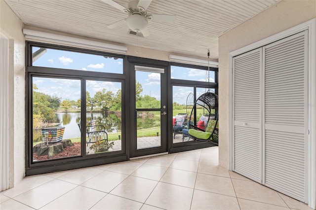 interior space with plenty of natural light, a water view, and ceiling fan