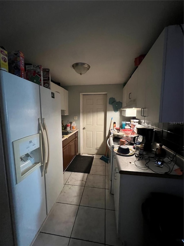 kitchen featuring white cabinets, white appliances, and light tile patterned flooring