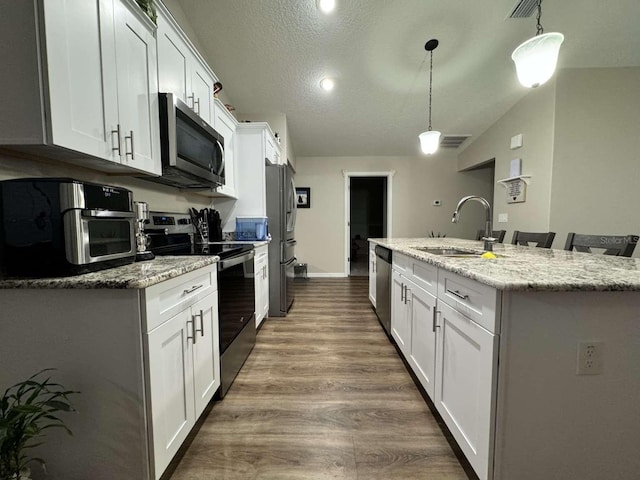 kitchen featuring sink, a textured ceiling, decorative light fixtures, white cabinetry, and stainless steel appliances