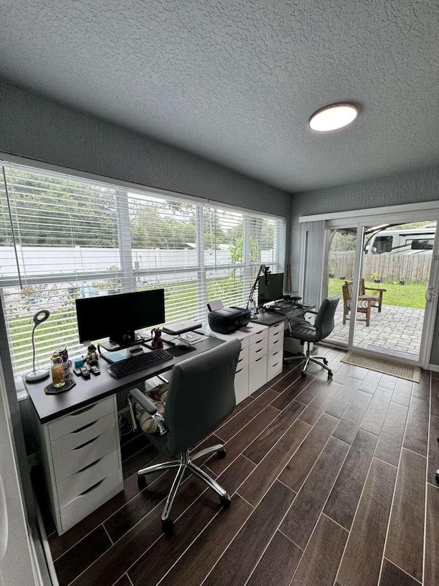 office area with a textured ceiling and dark wood-type flooring