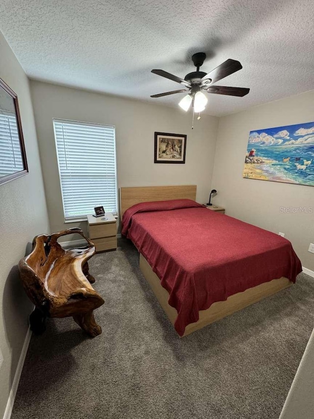 carpeted bedroom featuring ceiling fan and a textured ceiling