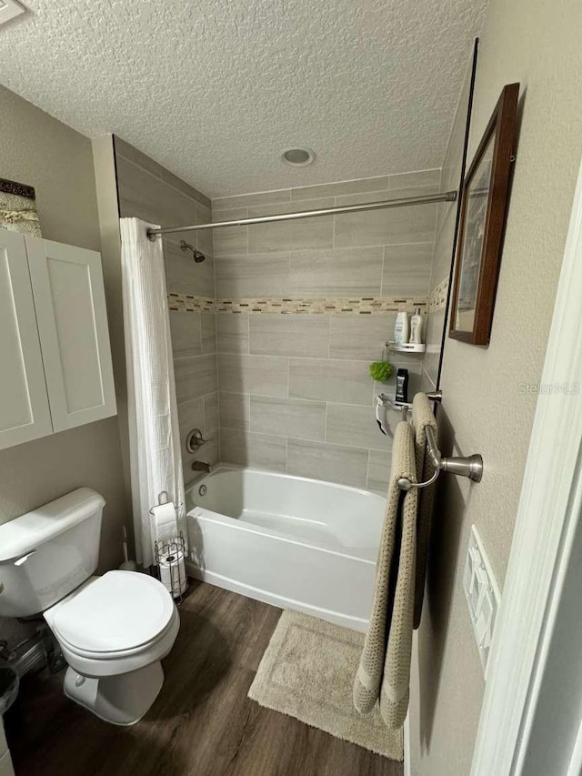 bathroom featuring toilet, shower / tub combo with curtain, a textured ceiling, and hardwood / wood-style flooring