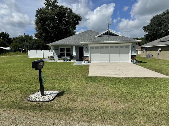 view of front facade featuring a front yard, a garage, and central AC unit