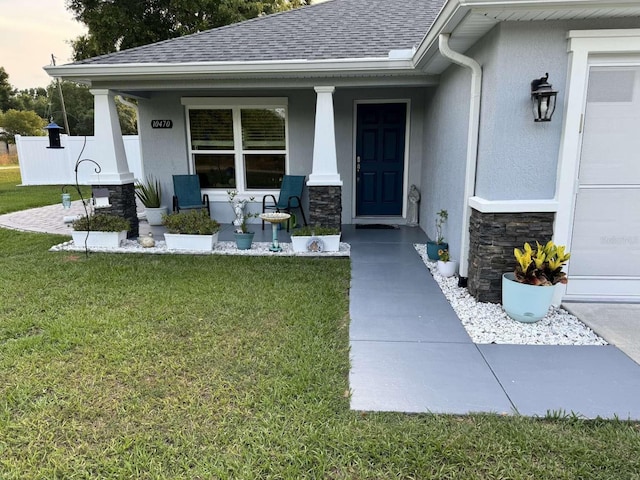 exterior entry at dusk featuring a porch and a yard