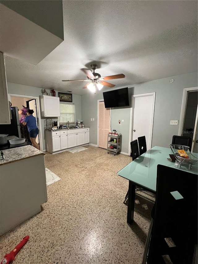 office with ceiling fan, sink, and a textured ceiling