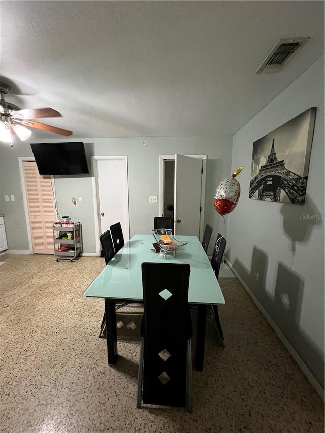 dining area featuring ceiling fan and a textured ceiling