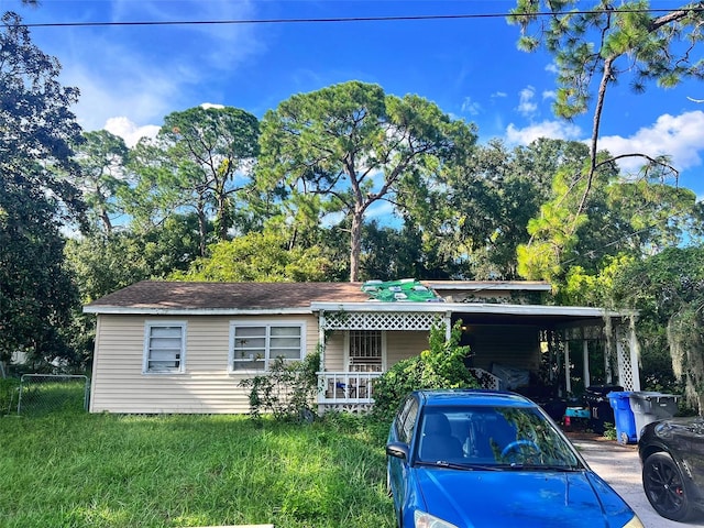 view of front of property with a front yard and a carport