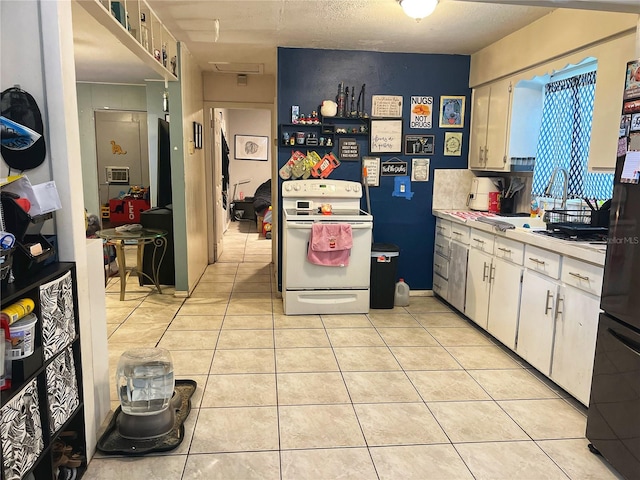 kitchen with white cabinets, a textured ceiling, light tile patterned flooring, and white electric range oven