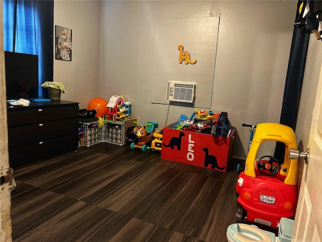 recreation room with dark hardwood / wood-style floors and a wall mounted air conditioner