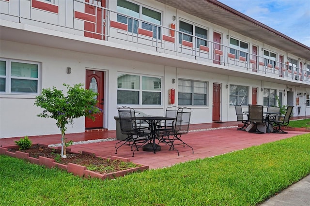 exterior space featuring a patio, a yard, and a balcony