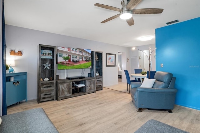 living room featuring ceiling fan and light hardwood / wood-style flooring