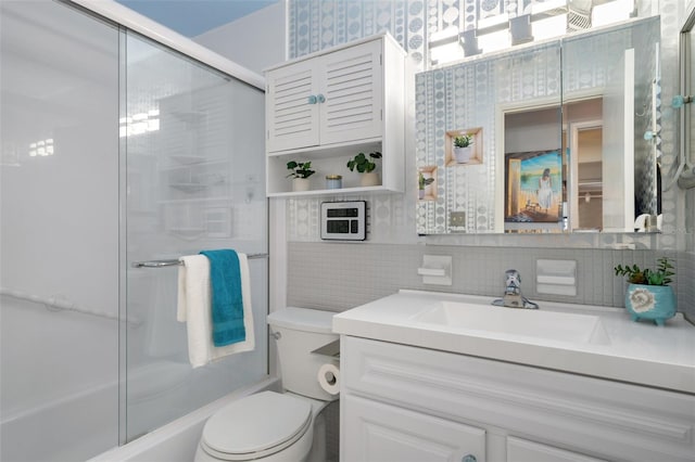 full bathroom with enclosed tub / shower combo, vanity, backsplash, tile walls, and toilet