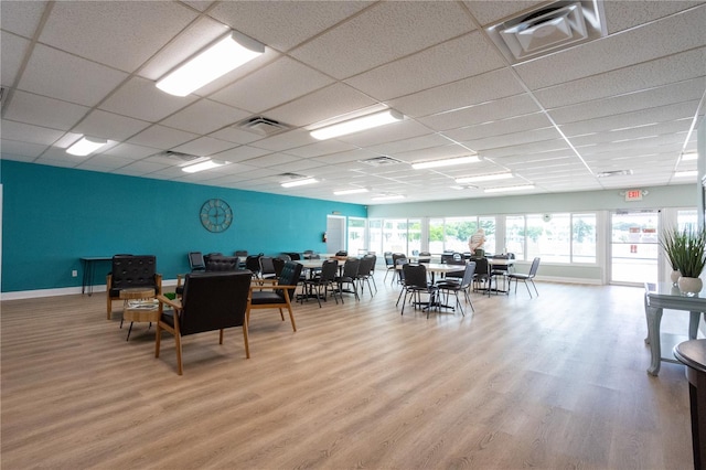 dining area with wood-type flooring and a drop ceiling