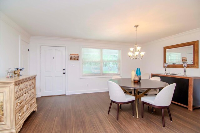 dining space featuring dark wood-type flooring, a chandelier, and crown molding