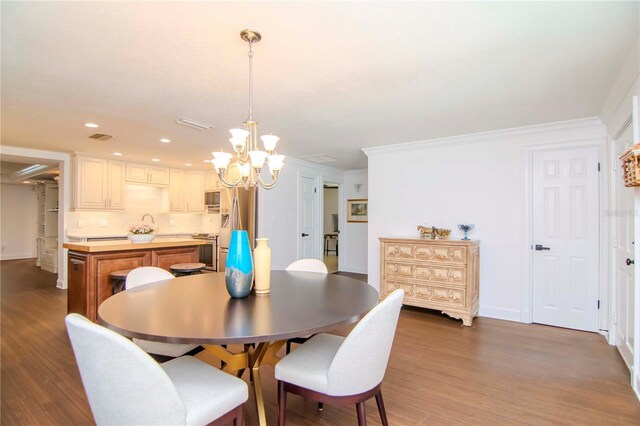 dining room featuring hardwood / wood-style floors, a notable chandelier, and crown molding