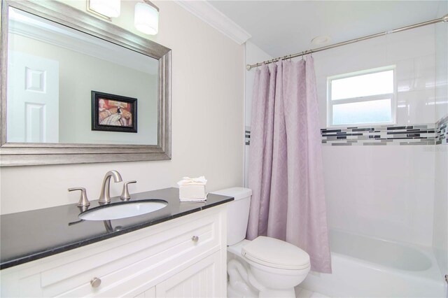 full bathroom featuring ornamental molding, vanity, toilet, and shower / bath combo