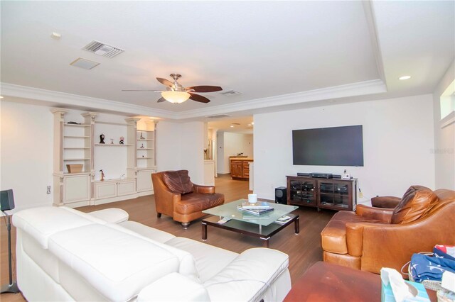 living room featuring ceiling fan, decorative columns, wood-type flooring, and ornamental molding