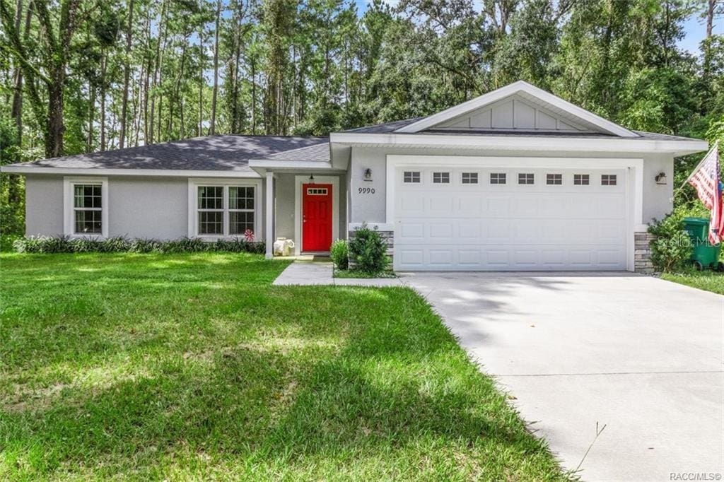 single story home with a garage and a front lawn