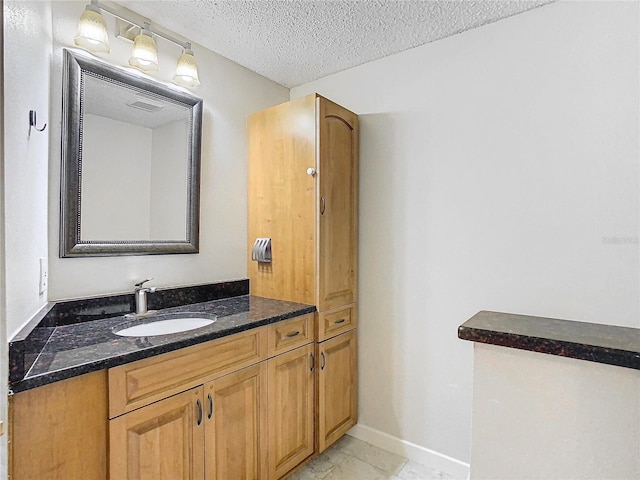 bathroom with vanity, a textured ceiling, and tile patterned flooring