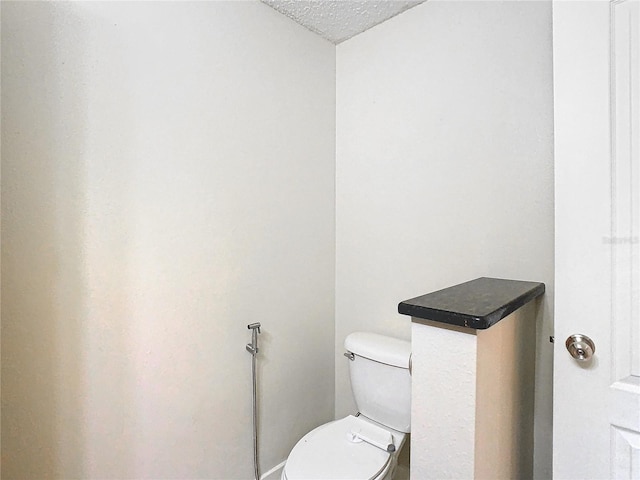 bathroom featuring toilet and a textured ceiling