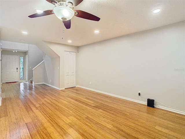 unfurnished living room with light wood-type flooring and ceiling fan